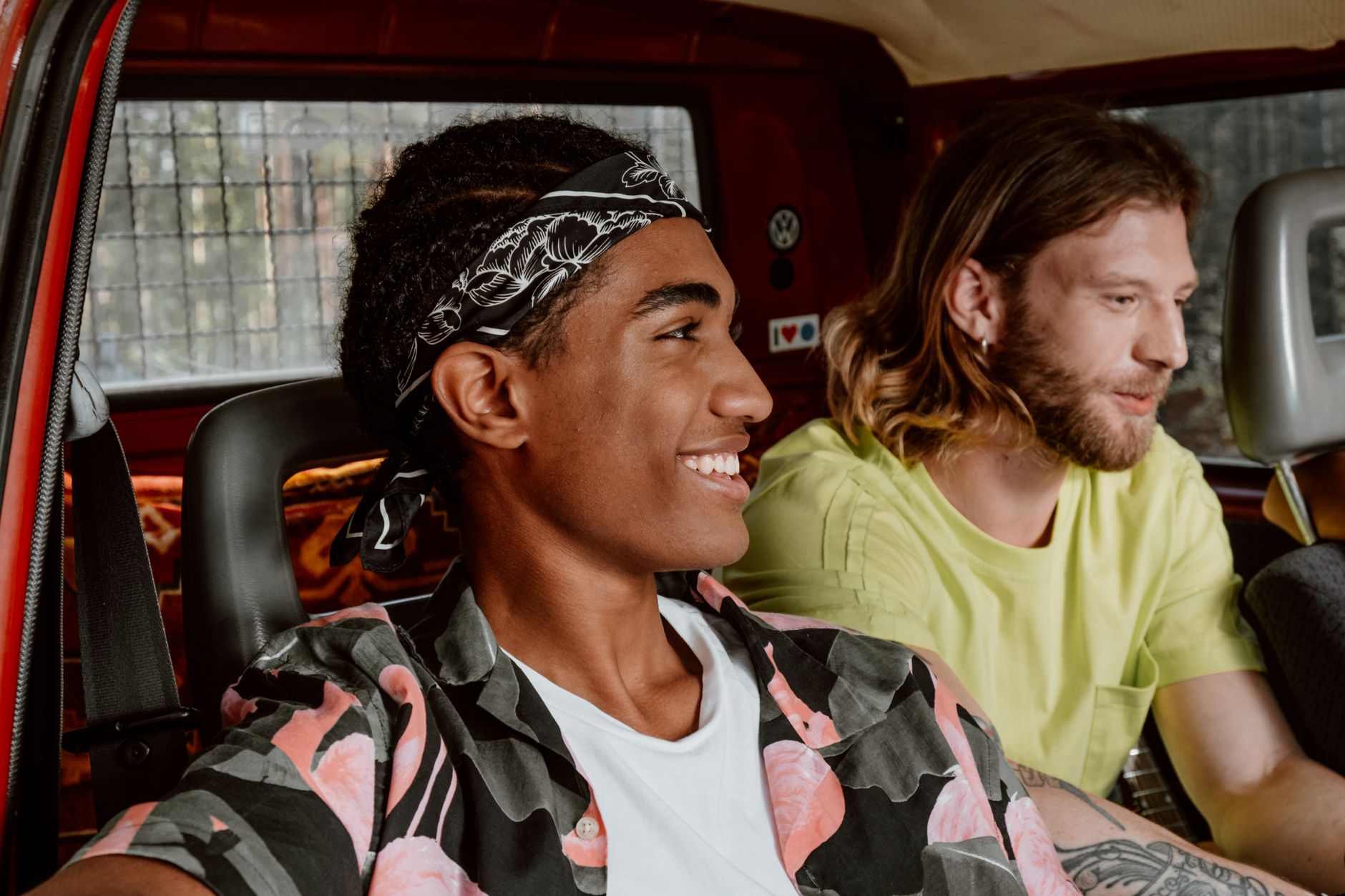 Zwei Freunde sitzen gut gelaunt zusammen im Auto
